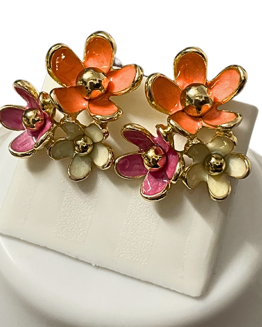 Close-up of KLYAA Blush Bloom anti-tarnish floral stud earrings on display with flower backdrop