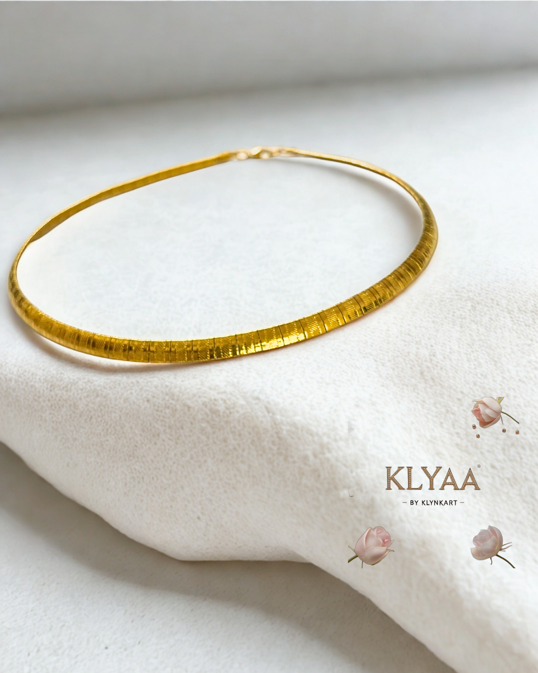 Sleek anti-tarnish gold choker chain laid on white fabric surface