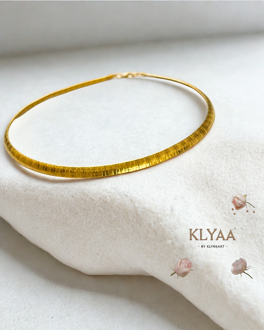 Sleek anti-tarnish gold choker chain laid on white fabric surface