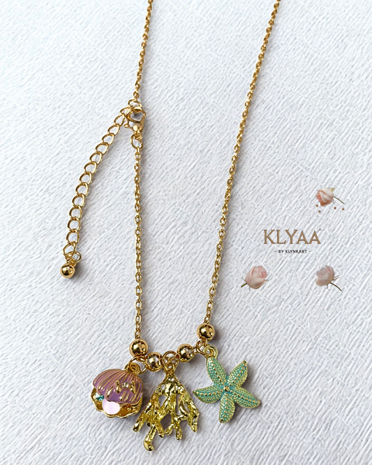 Luxury gold chain with ocean-inspired charms, featuring a purple seashell, gold coral, and blue starfish by KLYAA