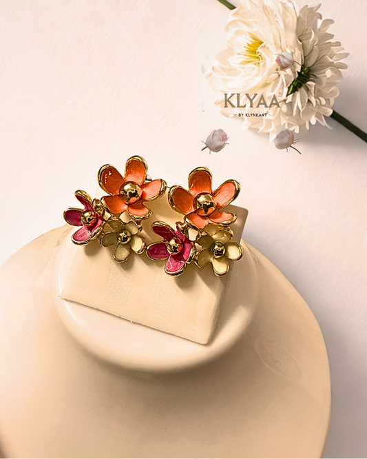 Zoomed view of blush and coral enamel floral stud earrings with gold detailing by KLYAA