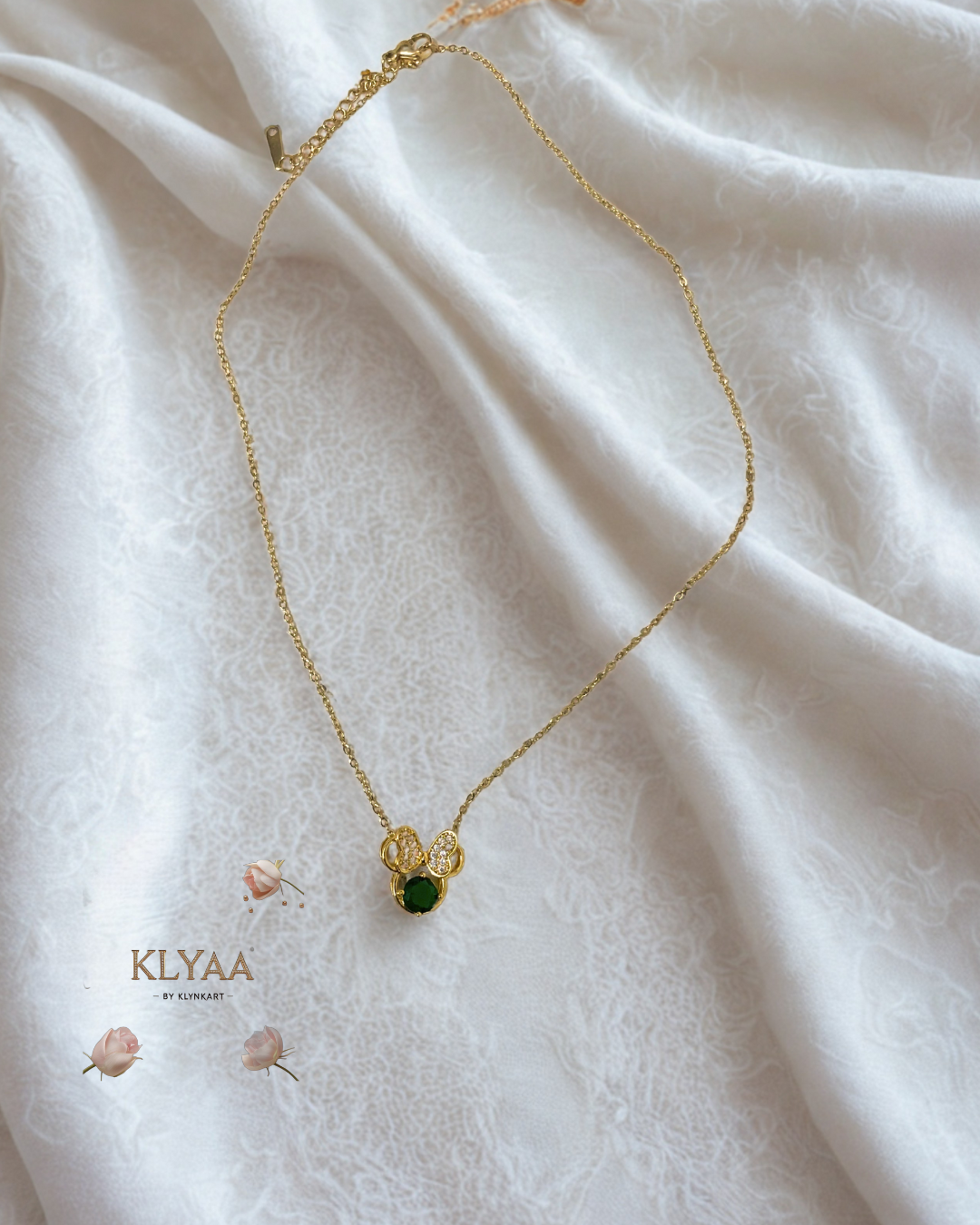 Gold plated Minnie pendant chain with emerald stone on white silk background – KLYAA