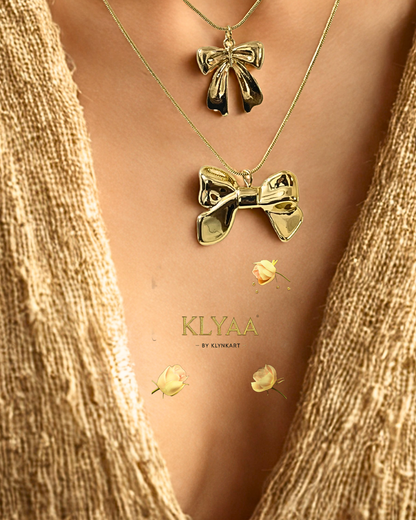 Close-up of layered gold bow necklace on bust display with lace frame – KLYAA premium chain